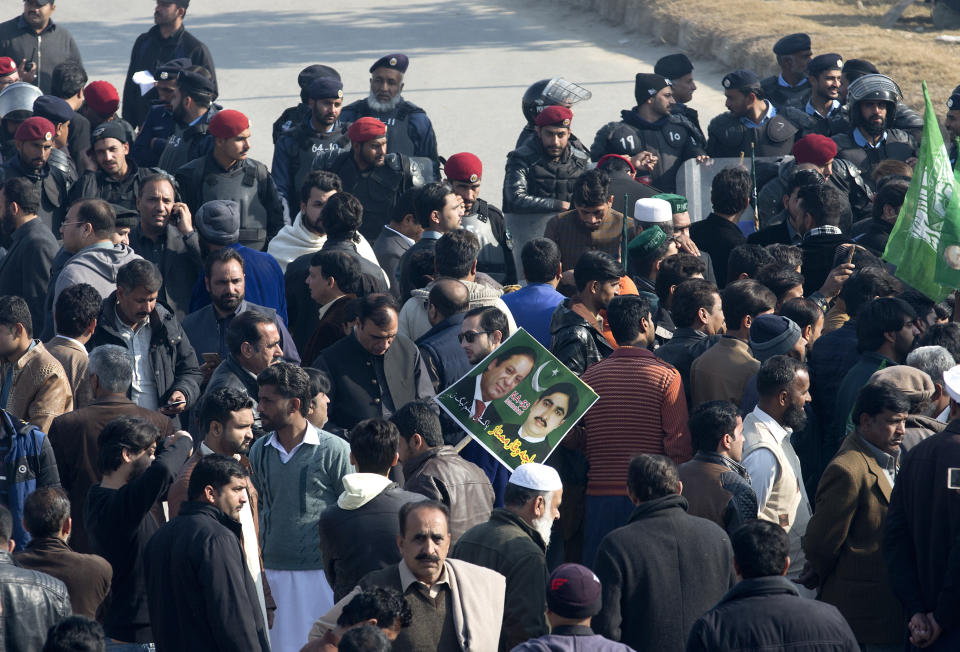 Police, rear, block supporters of former Pakistani Prime Minister Nawaz Sharif outside an accountability court in Islamabad, Pakistan, Monday, Dec. 24, 2018. Pakistan's anti-graft court is set to announce ruling in two corruption cases against Sharif. Sharif, accused of possessing assets beyond known sources of income, will be sent to jail if he is sentenced. (AP Photo/B.K. Bangash)