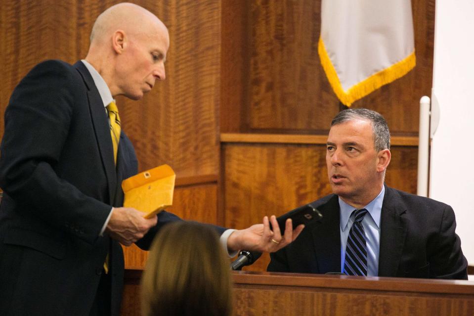 District Attorney William McCauley (L) reviews the cell phone recovered from Odin Lloyd with North Attleboro Detective Michael Elliot during the murder trial for former NFL player Aaron Hernandez at the Bristol County Superior Court in Fall River, Massachusetts, February 17, 2015. REUTERS/Dominick Reuter (UNITED STATES - Tags: CRIME LAW)