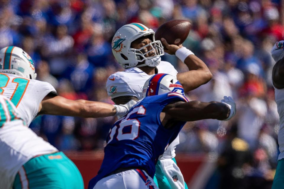 Dolphins quarterback Tua Tagovailoa throws a pass while pressured by Bills defensive end Leonard Floyd.