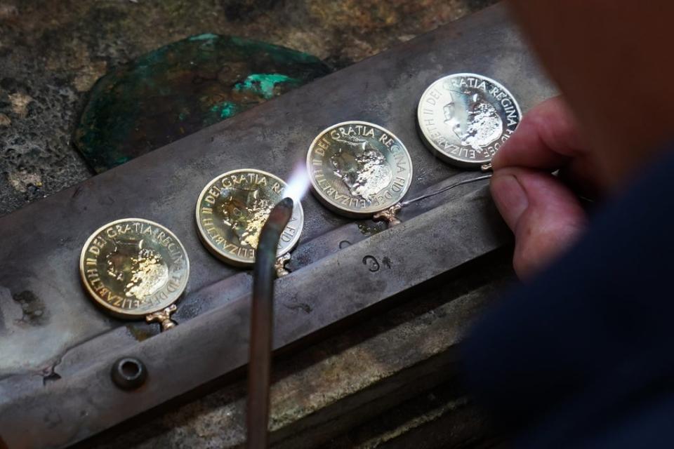 Rings to hold ribbons are soldered to Platinum Jubilee medals. Joe Giddens/PA Wire (PA)