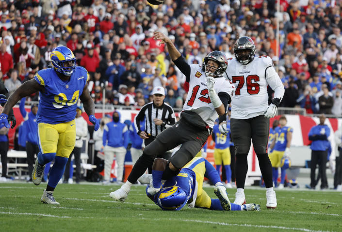 TAMPA BAY, FLA - El linebacker de Los Angeles Rams Obo Okoronkwo (45) atrapa por las piernas al quarterbackde los Tampa Bay Buccaneers, Tom Brady (12), en el partido del playoff divisoinal en el Raymond James Stadium el 23 de enero de 2022 en Tampa Bay, Florida.(Gina Ferazzi / Los Angeles Times via Getty Images)