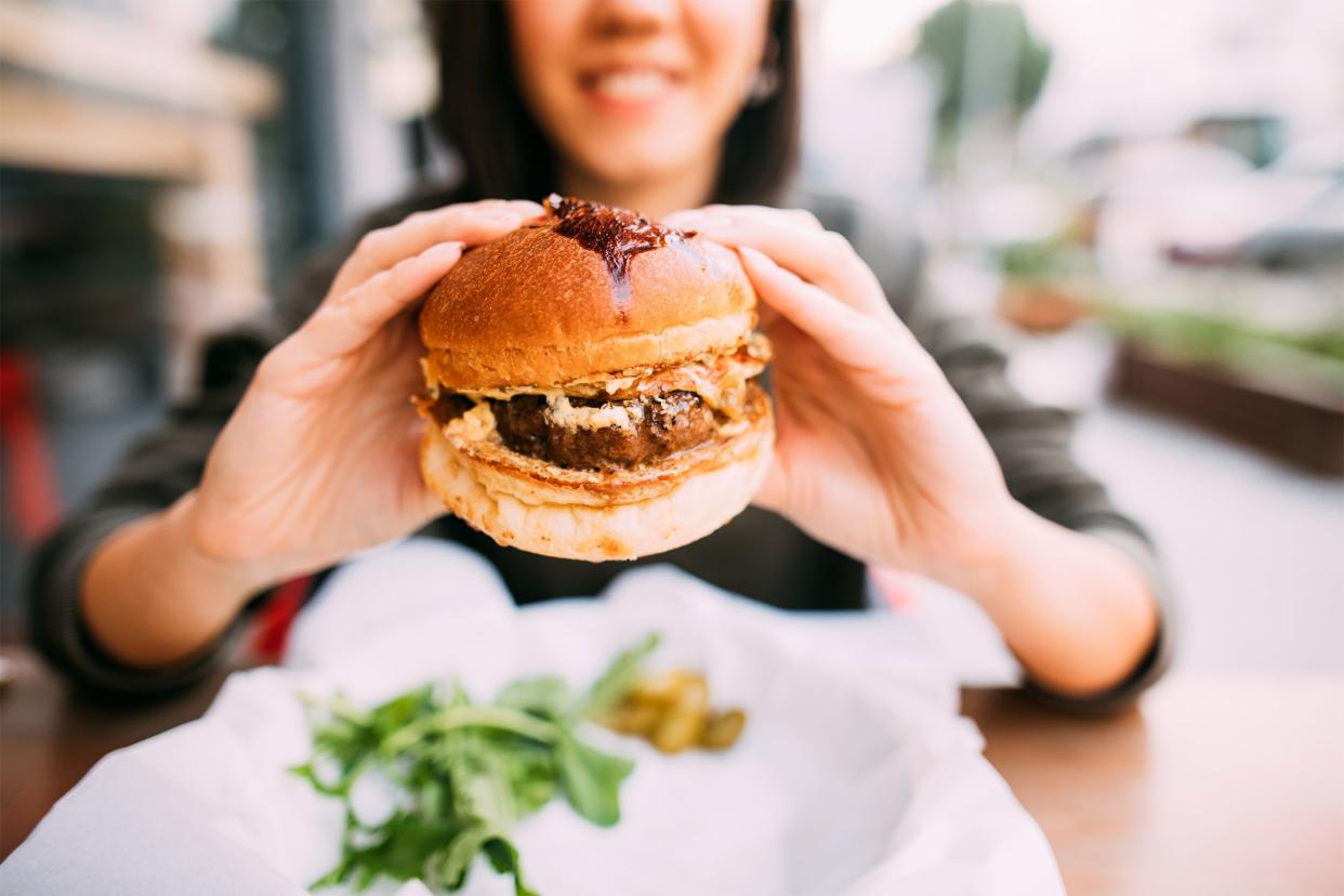 Closeup of burger with woman in background