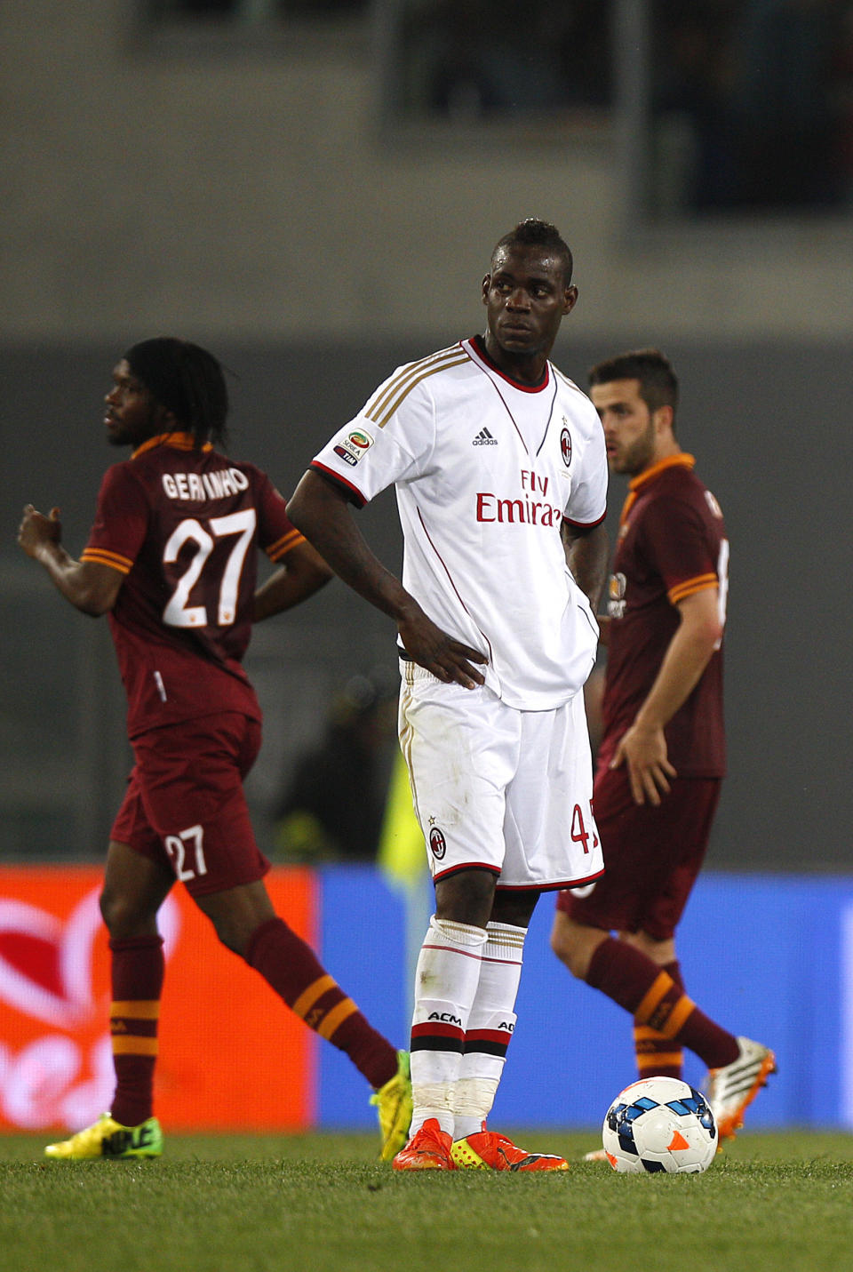 AC Milan's Mario Balotelli, center, stands by the ball after AS Roma midfielder Miralem Pjanic, right, scored during an Italian Serie A soccer match between Roma and AC Milan at Rome's Olympic stadium, Friday, April 25, 2014. (AP Photo/Alessandra Tarantino)