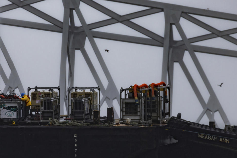 Cranes continue salvage work as wreckage of the Francis Scott Key Bridge rests on the container ship Dali, Wednesday, April 3, 2024, in Baltimore. (AP Photo/Julia Nikhinson)