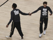 Atlanta Hawks' John Collins, left, and Trae Young wear shirts honoring Dr. Martin Luther King, Jr. as they prepare to play the Minnesota Timberwolves in an NBA basketball game on Martin Luther King Day, Monday, Jan. 18, 2021, in Atlanta. (Curtis Compton/Atlanta Journal-Constitution via AP)