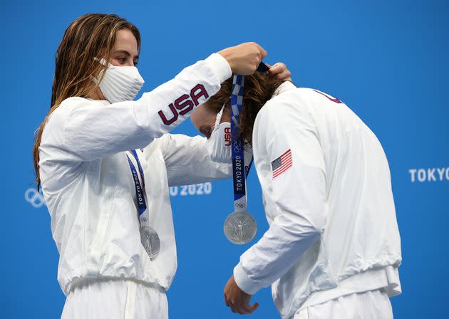 Katie McLaughlin of Team United States places a silver medal around the neck of her teammate Katie Ledecky during the ceremony for the women's 4 x 200-meter freestyle relay on July 29. McLaughlin and Ledecky earned silver alongside teammates Allison Schmitt and Paige Madden. (Photo: Tom Pennington via Getty Images)