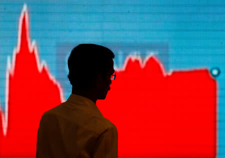 A man walks past a screen displaying news of markets update inside the Bombay Stock Exchange (BSE) building in Mumbai, February 6, 2018. REUTERS/Danish Siddiqui/Files