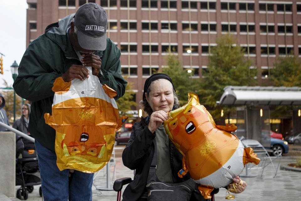 Cary Garrett, left, blows up a small "Baby Trump Balloon" as Leslie Thomasson adjusts her balloon during a MoveOn "No One is Above the Law" protest at Miller Park on Thursday, Nov. 8, 2018 in Chattanooga, Tenn. The protestors gathered to voice objections to President Trump's appointment of Matthew Whitaker as acting attorney general. (C.B. Schmelter/Chattanooga Times Free Press via AP)