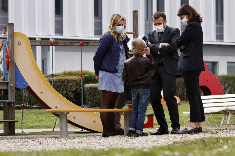 French President Emmanuel Macron talks to a child as he visits a child psychiatry department at Reims hospital, eastern France, to discuss the psychological impact of the COVID-19 crisis and the lockdown on children and teenagers in France, Wednesday, April 14, 2021. (Christian Hartmann/Pool via AP)