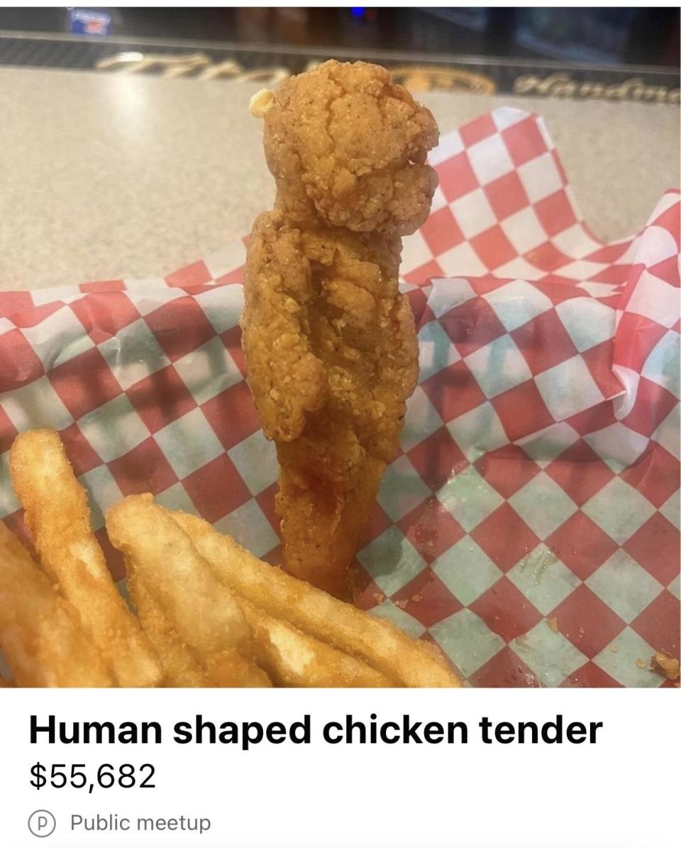 Chicken tender resembling a human figure next to fries on checkered paper