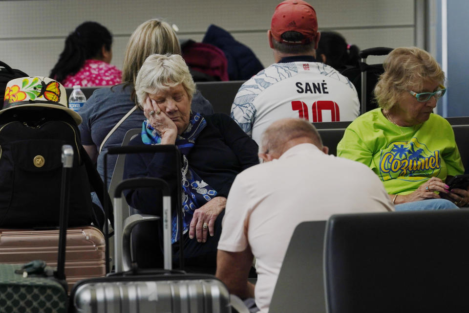 Passengers wait for their flight at Fort Lauderdale-Hollywood International Airport, Friday, April 14, 2023, in Fort Lauderdale, Fla. The airport reopened after it was forced to cancel flights yesterday following heavy rain that flooded the runways. One runway remains closed. (AP Photo/Marta Lavandier)