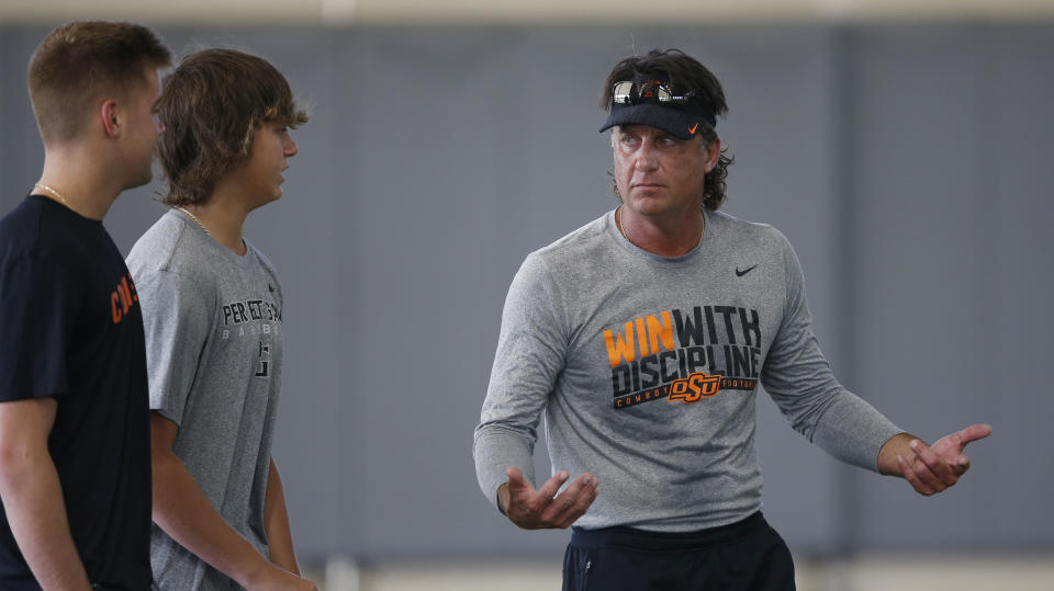 Oklahoma State head coach Mike Gundy, right, talks with his sons, Gunnar Gundy, left, and Gage Gundy, center, during an NCAA college football practice in Stillwater Okla., Tuesday, Aug. 6, 2019. (AP Photo/Sue Ogrocki)