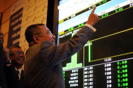 Chairman of Felda Global Ventures Holding Berhad Mohd Isa Abdul Samad points to a digital display showing share prices after the listing debut of Felda Global on the Malaysia Stock Exchange in Kuala Lumpur on June 28, 2012. Malaysia is tipped to be Asia's top IPO market for 2012 thanks to two of the world's biggest company listings this year, but analysts say the momentum is likely to fizzle out