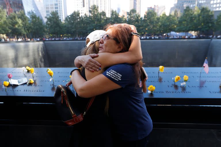 Melinda Moran y Haydee Lillo se abrazan después de descubrir que perdieron a personas que se conocían, junto al North Reflecting Pool en el National September 11 Memorial