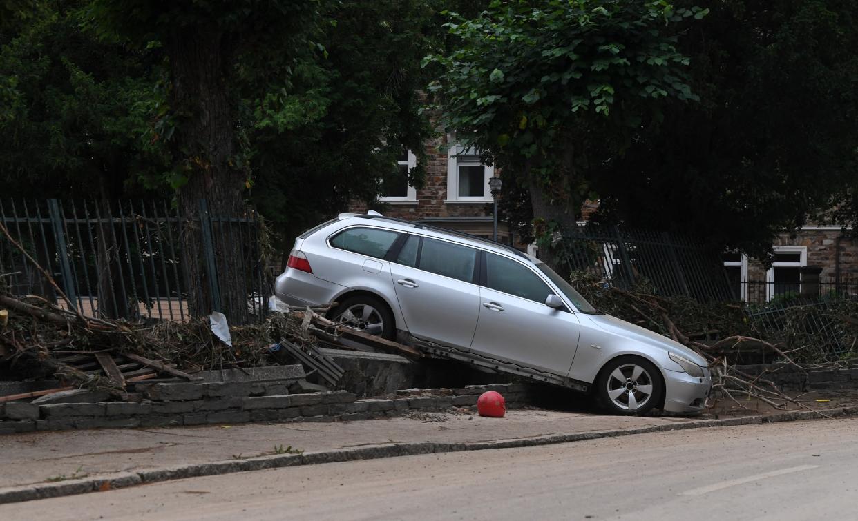 A damaged car, washed away by flood waters sits on some debris in a street in the town of Ahrweiler-Bad Neuenahr on July 15, 2021. - Heavy rains and floods lashing western Europe have killed at least 45 people in Germany and left around 50 missing, as rising waters led several houses to collapse. (Photo by Christof STACHE / AFP) (Photo by CHRISTOF STACHE/AFP via Getty Images)