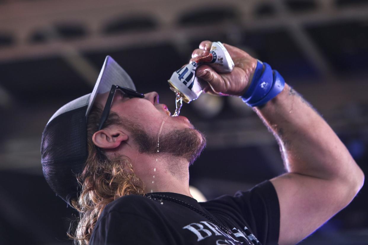 A man downs a beer onstage during a wet T-shirt competition at Dirty Harry’s Pub in Daytona, FL during Bike Week on March 5, 2021. (Sam Thomas/Orlando Sentinel)