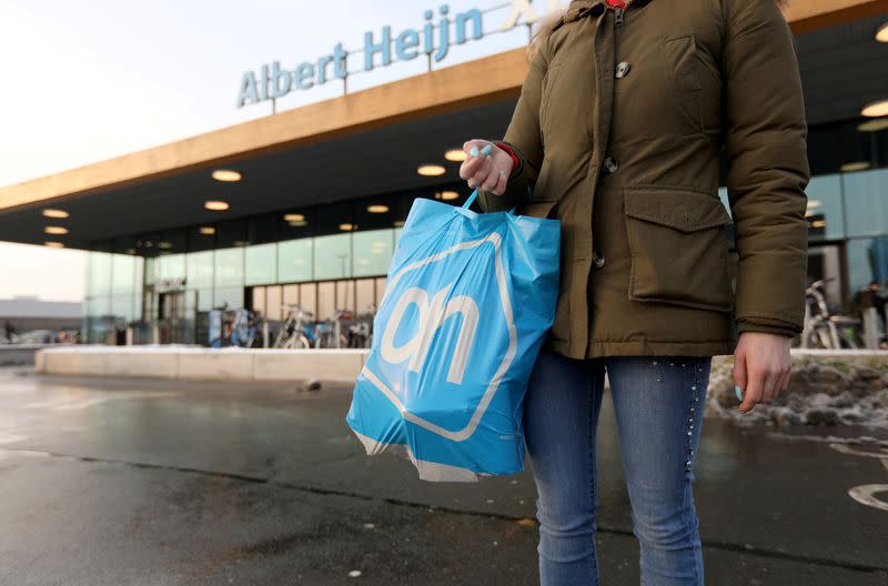 FILE PHOTO: A woman holds a bag with the logo of Albert Heijn, operated by Ahold Delhaize, the Dutch-Belgian supermarket operator, in Eindhoven