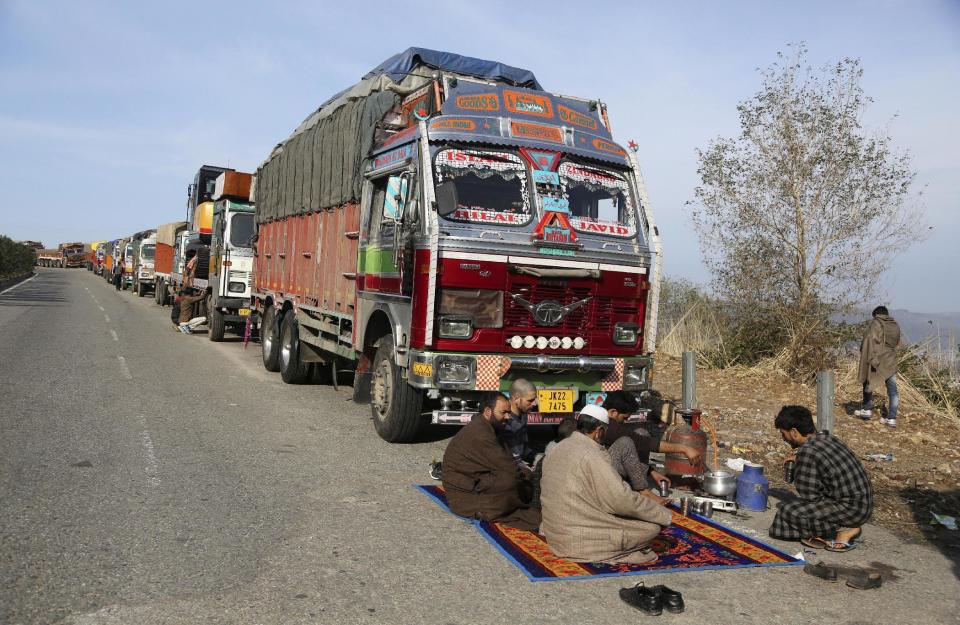 Stranded truck drivers drink tea sitting by their vehicles on the main highway connecting Jammu and Srinagar, on the outskirts of Jammu, India, Saturday, Jan.28,2017. Heavy snowfall has cut off roads and disrupted power and communications in Kashmir, and hundreds of residents have been evacuated from high-risk areas. (AP Photo/Channi Anand )