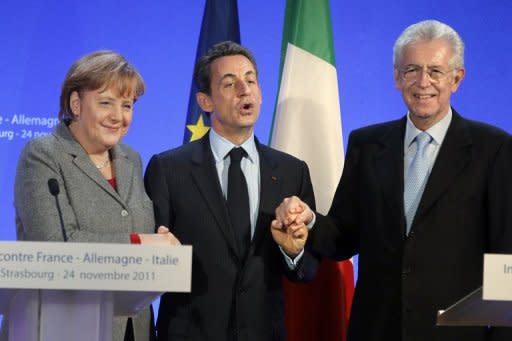 German Chancellor Angela Merkel (L), France's President Nicolas Sarkozy (C) and Italy's Prime Minister Mario Monti (R) shake hands at the end of a press conference in Strasbourg, eastern France, on November 24, 2011. The leaders of Germany, France and Italy are set for debate on the European Central Bank's role in the region's debt crisis and on how to align eurozone economic policies. AFP PHOTO POOL MICHEL EULER