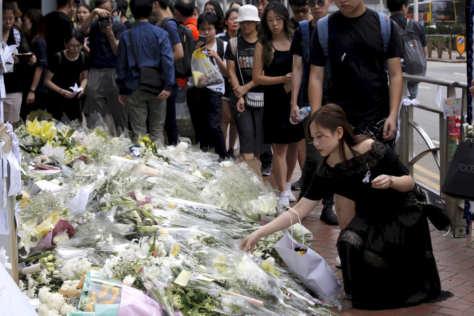 Mourners stop by a makeshift memorial, to lay flowers and pray for a man who fell to his death Saturday after hanging a protest banner against an extradition bill in Hong Kong Sunday, June 16, 2019. Tens of thousands of Hong Kong residents, mostly in black, have jammed the city’s streets Sunday to protest the government’s handling of a proposed extradition bill. (AP Photo/Kin Cheung)