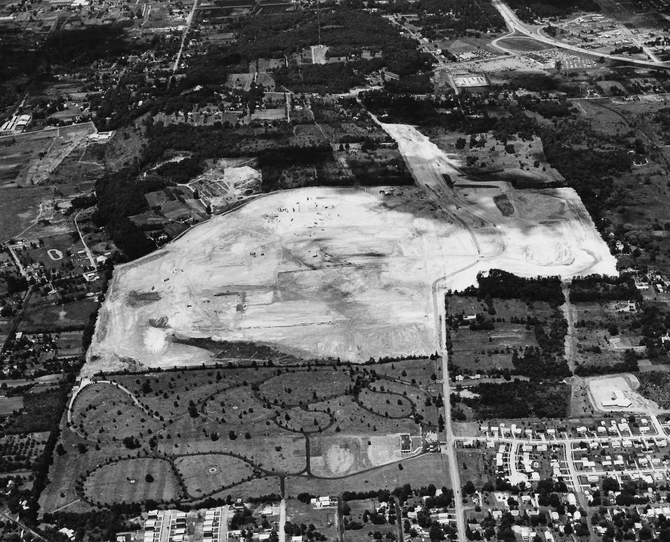 Land is cleared for Rolling Acres Mall in June 1974. Greenlawn Cemetery can be seen in the foreground.