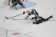 Colorado Avalanche left wing Joel Kiviranta (94) and Minnesota Wild right wing Mats Zuccarello (36) fight for the puck in the third period of an NHL hockey game Tuesday, April 9, 2024, in Denver. (AP Photo/Bart Young)