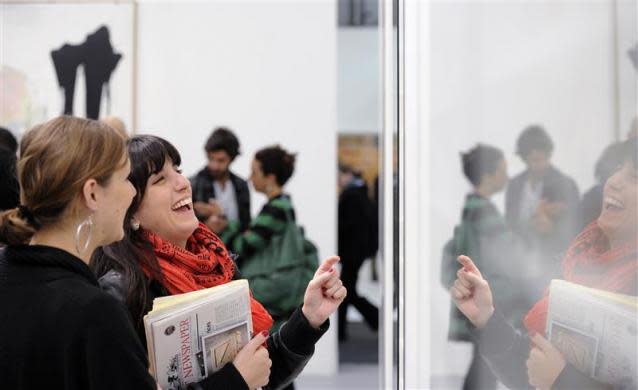 Women look at an exhibit by the artist Damien Hirst at the Frieze Art Fair in London October 14, 2010.