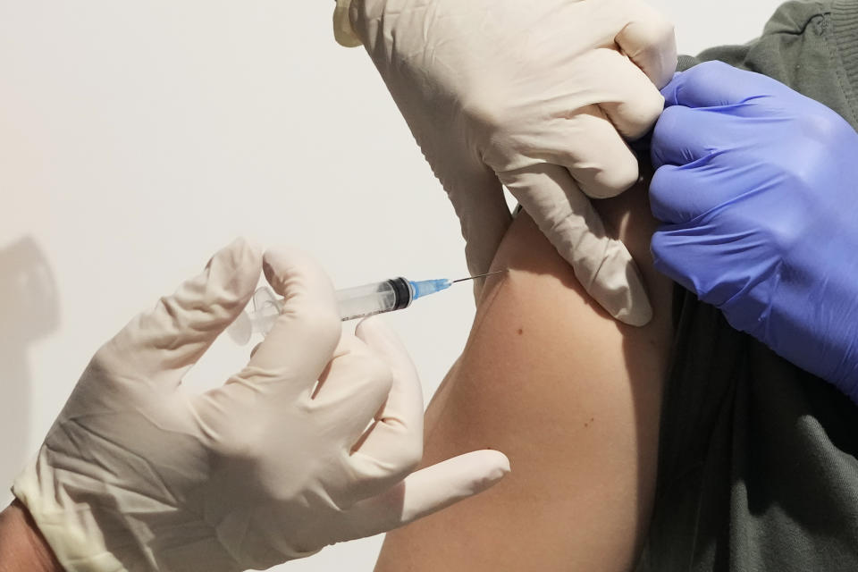 A medical worker administers a shot of Russia's Sputnik V coronavirus vaccine at a vaccination center in the GUM, State Department store, in Red Square in Moscow, Russia, Thursday, July 1, 2021. Russian health authorities on Thursday launched booster vaccination for those who had been sick with COVID-19 or immunized more than six months ago, an effort that comes amid a surge in new infections and deaths. (AP Photo/Pavel Golovkin)