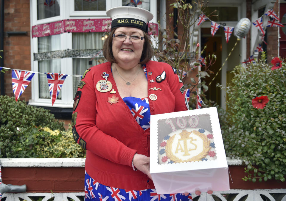 Kath Ryan delivers a cake to celebrate the 100th birthday of Leonora Jeffreys, a former Doodlebug spotter during World War II in Birmingham, England, Monday, Oct. 5, 2020. Ryan is behind Cakes 4 Casualties, baking thousands of cakes for service people who have been injured, many as they recover from wounds in hospital. (AP Photo/Rui Vieira)