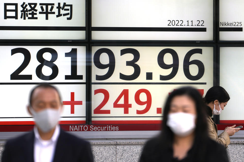 People walk past an electronic stock board showing Japan's Nikkei 225 index at a securities firm Tuesday, Nov. 22, 2022, in Tokyo. Asian stock markets were mixed Tuesday after Wall Street sank and Chinese anti-virus controls fueled concern about an economic slowdown. (AP Photo/Shuji Kajiyama)