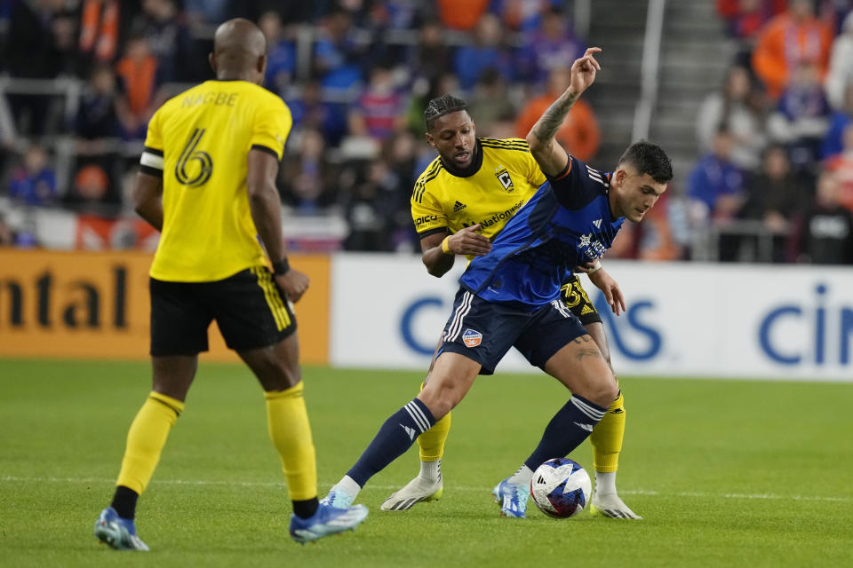 Columbus Crew defender Steven Moreira, rear, and FC Cincinnati forward Brandon Vázquez vie for the ball as Crew midfielder Darlington Nagbe moves in during the first half of the MLS Eastern Conference final soccer match Saturday, Dec. 2, 2023, in Cincinnati. (AP Photo/Carolyn Kaster)