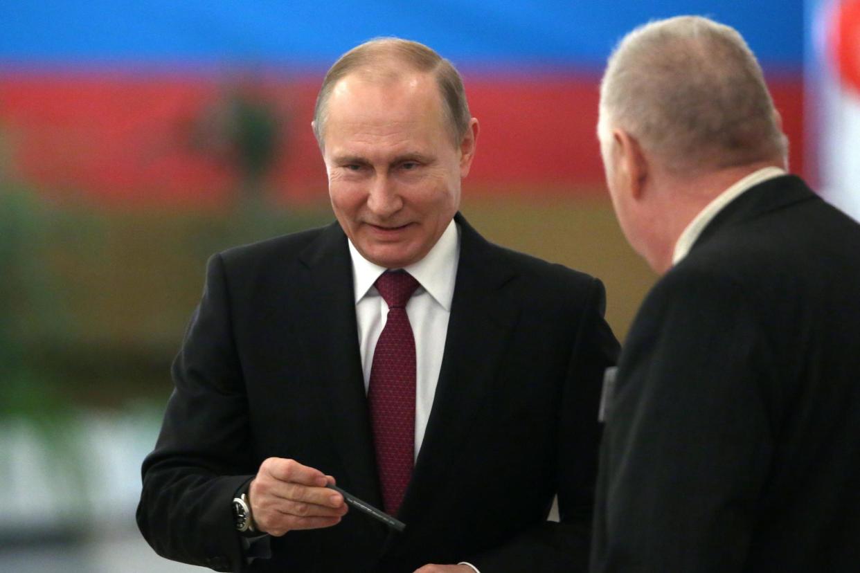 Russian President Vladimir Putin leaves a voting booth at a polling station in Moscow: EPA