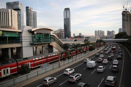 Cars drive on a highway as a train enters a station in Tel Aviv, Israel November 25, 2018. Picture taken November 25, 2018. REUTERS/Corinna Kern