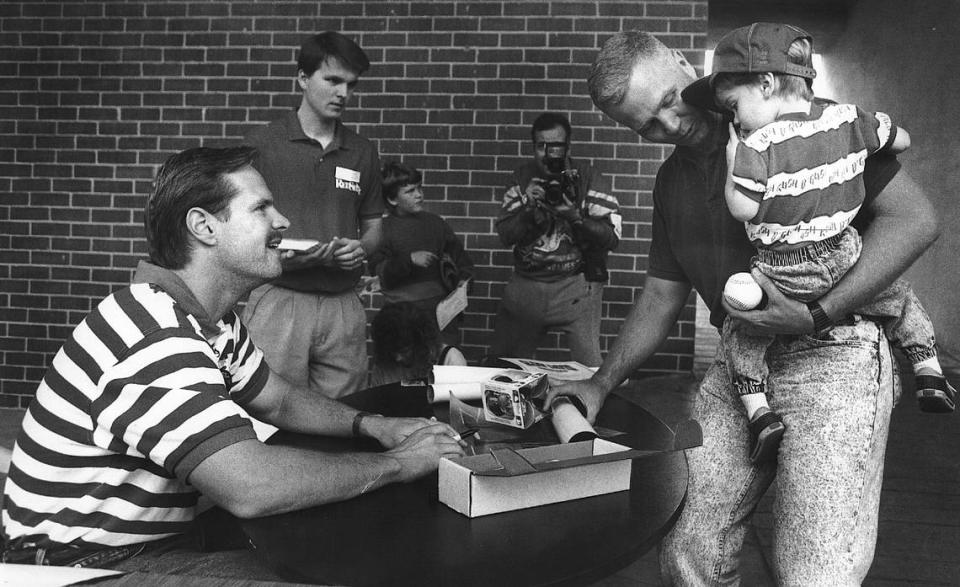 Former major league baseball player, and current Columbus city councilor Glenn Davis, seated left, signs autographs at Golden Park in Columbus, Georgia.