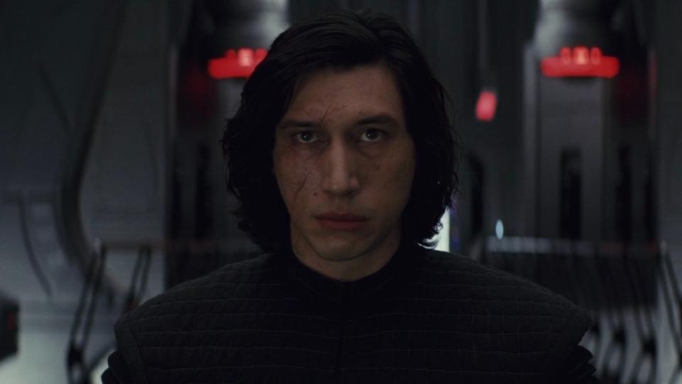 A solemn Kylo Ren without his helmet stands before Snoke in The Last JEdi