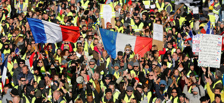 Protesters wearing yellow vests wave French flags as they take part in a demonstration of the "yellow vests" movement in Marseille, France, December 15, 2018. REUTERS/Jean-Paul Pelissier