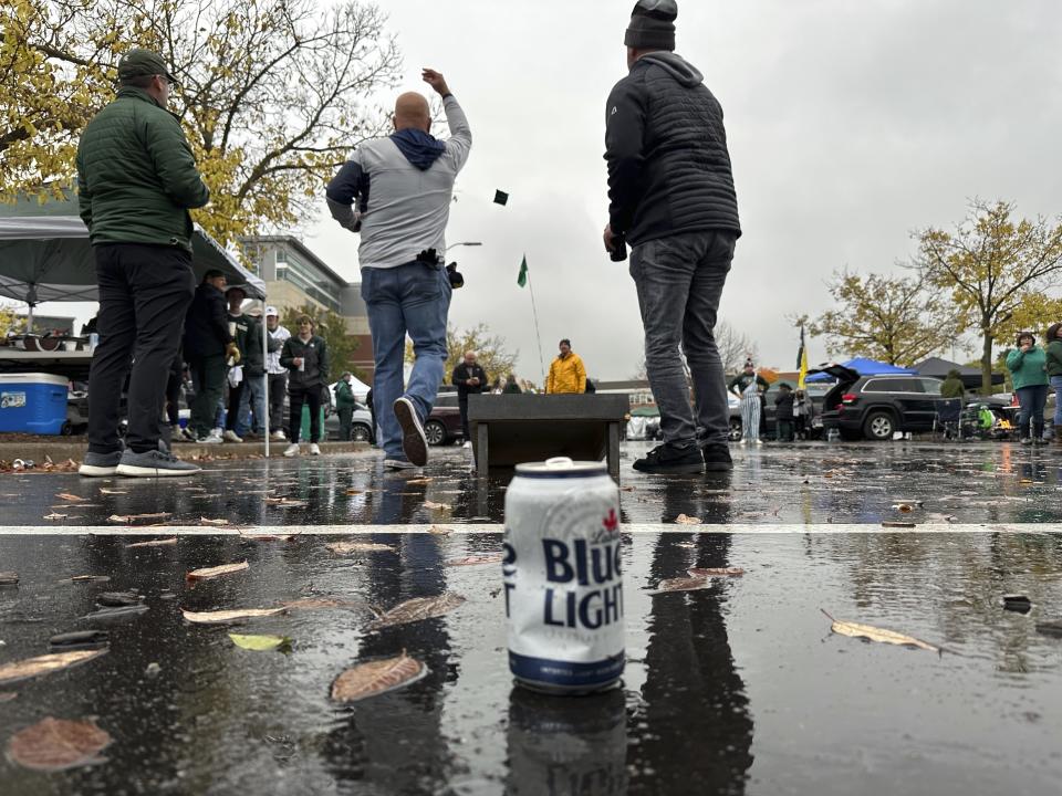 Tailgaters play cornhole outside Spartan Stadium before the Michigan-Michigan State football game Saturday, Oct. 21, 2023, in East Lansing, Mich. Michigan State University started selling alcoholic beverages at the stadium this fall. According to a survey by The Associated Press of Power Five conference schools and Notre Dame, 55 of 69 of them sell alcohol in the public areas of their stadiums on game days. (AP Photo/Mike Householder)