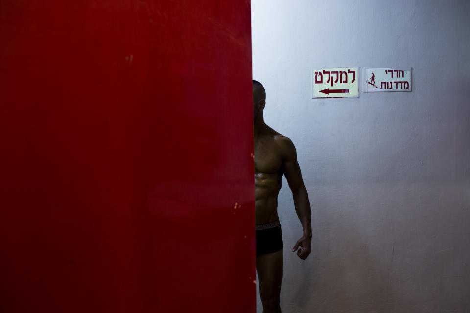 In this Thursday, Oct. 18, 2018 photo, a contestant has his body painted backstage during the National Amateur Body Builders' Association competition in Tel Aviv, Israel. (AP Photo/Oded Balilty)