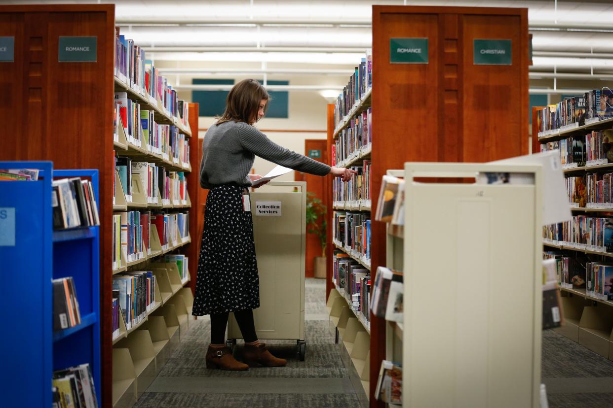 Librarian Miranda Eudaly restocks books at The Library Center on Friday, Jan. 19, 2024.