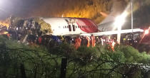 First responders gather around the wreckage of an Air India Express jet, which was carrying more than 190 passengers and crew from Dubai, after it crashed by overshooting the runway at Calicut International Airport in Karipur, Kerala, on August 7, 2020. - At least 19 people died when a passenger jet skidded off the runway after landing in heavy rain in India. (Photo by - / AFP) (Photo by -/AFP via Getty Images)