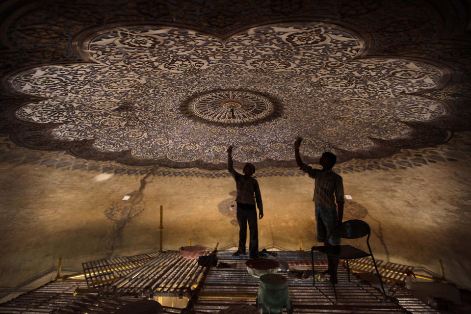 In this June 7, 2013, photo, Indian laborers work to renovate the Neela Gumbad, or Blue Tomb, as part of a project for the creation of a mammoth, iconic park that would rival New York's Central Park as a refuge from urban chaos in New Delhi. To create that park would require the merger of a string of adjoining gardens, heritage areas and a zoo administered by different government agencies, an incredibly complicated task in a land where bureaucratic turfs are fiercely protected. It would be 1,200 acres, considerably larger than Central Park. It would encompass one of the most impressive collections of medieval Islamic monuments, anchored by the grandiose tomb of Emperor Humayun, a 16th Century prototype for the Taj Mahal. (AP Photo/Manish Swarup)