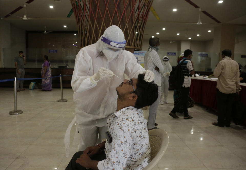 A health worker takes a nasal swab sample to test for COVID-19 at a state bus station in Ahmedabad, India, Saturday, Aug. 29, 2020. India has the third-highest coronavirus caseload after the United States and Brazil, and the fourth-highest death toll in the world. (AP Photo/Ajit Solanki)