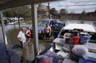 People stand in floodwaters while salvaging items from their flood-damaged home in the aftermath of Hurricane Ida, Wednesday, Sept. 1, 2021, in Jean Lafitte, La. Louisiana residents still reeling from flooding and damage caused by Hurricane Ida scrambled Wednesday for food, gas, water and relief from the sweltering heat as thousands of line workers toiled to restore electricity and officials vowed to set up more sites where people could get free meals and cool off. (AP Photo/John Locher)