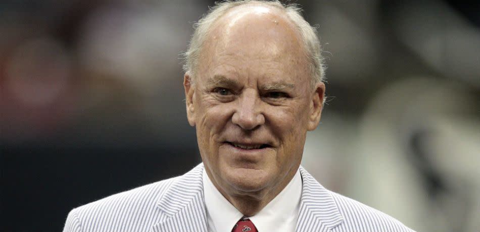 Houston Texans owner Bob McNair smiling in white suit and red tie.