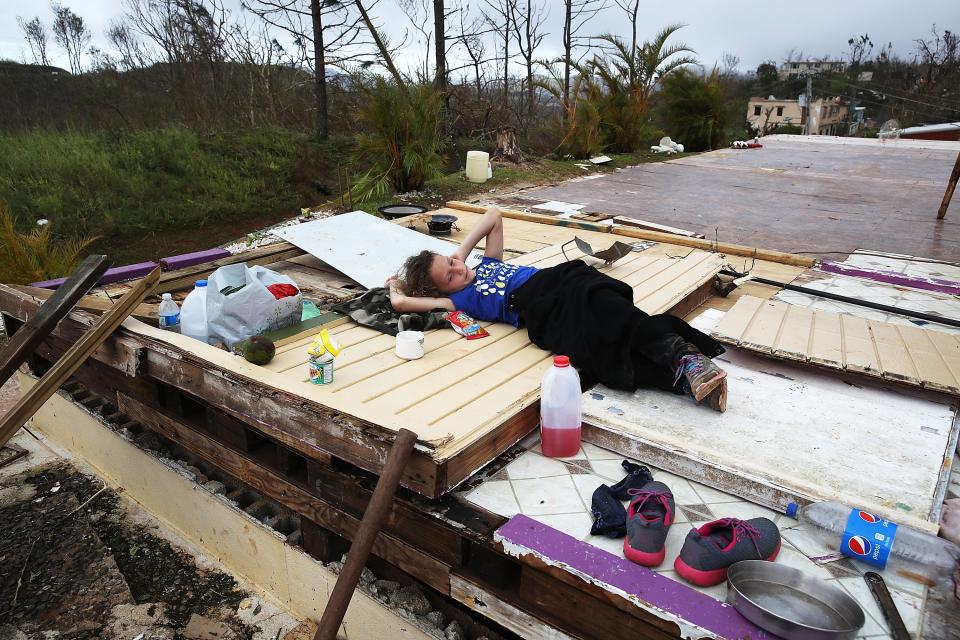 <p>Karlian Mercado, de 7 años, reposa sobre lo poco que queda de la casa de su familia Coamo. (Photo by Joe Raedle/Getty Images) </p>