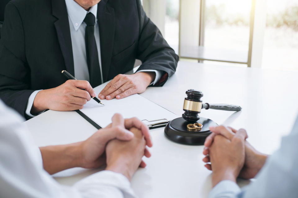 set of 3 hands on a table while someone does paperwork