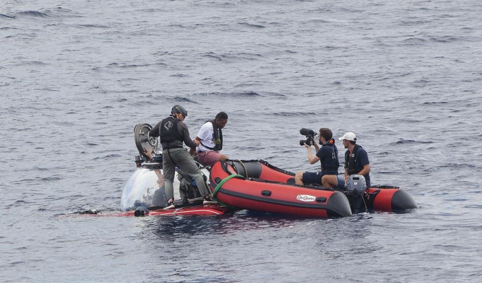 Seychelles President Danny Faure disembarks from a submersible, off the coast of Seychelles on Sunday April 14, 2019. In a striking speech delivered from deep below the ocean's surface, the Seychelles president on Sunday made a global plea for stronger protection of the "beating blue heart of our planet." President Danny Faure's call for action, the first-ever live speech from an underwater submersible, came from one of the many island nations threatened by global warming.(AP Photo/Steve Barker)