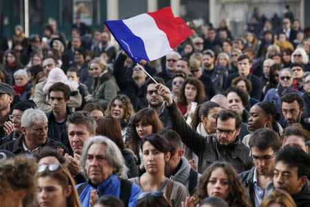 A man waves a French flag as several hundred people gather to observe a minute of silence in Lyon, France, November 16, 2015, to pay tribute to the victims of the series of deadly attacks in Paris on Friday. REUTERS/Robert Pratta