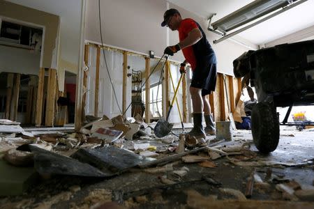 Gary Howard cleans out his flood damaged garage at the South Point subdivision in Denham Springs, Louisiana, U.S., August 22, 2016. REUTERS/Jonathan Bachman