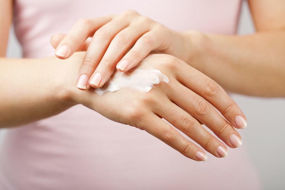 feminine hands applying hand cream